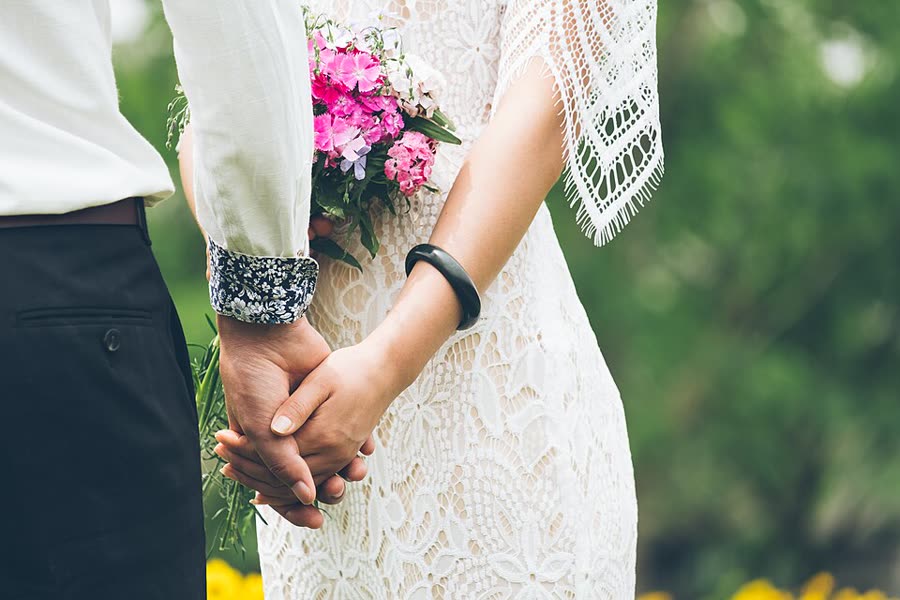Las manos de los novios y el ramo