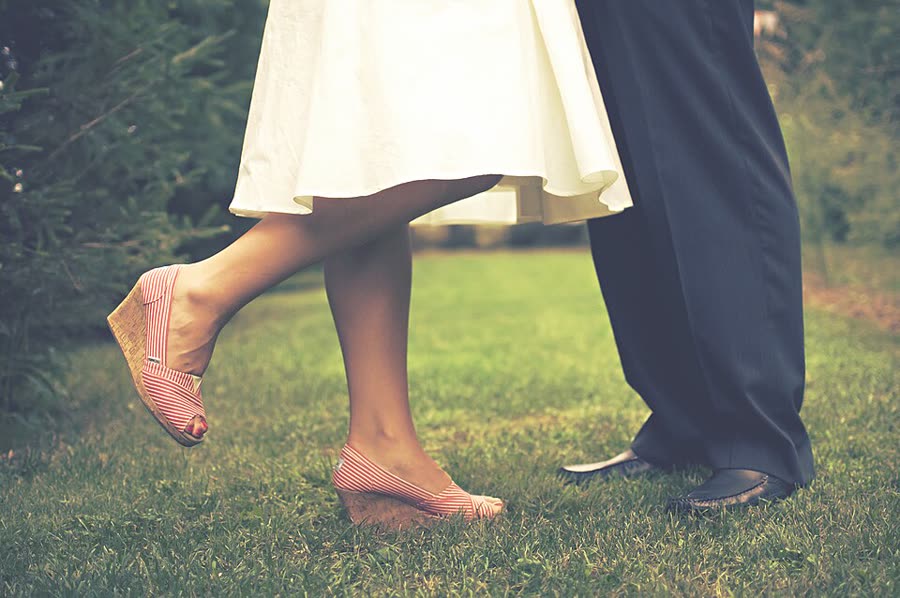 Los novios parados sobre el pasto